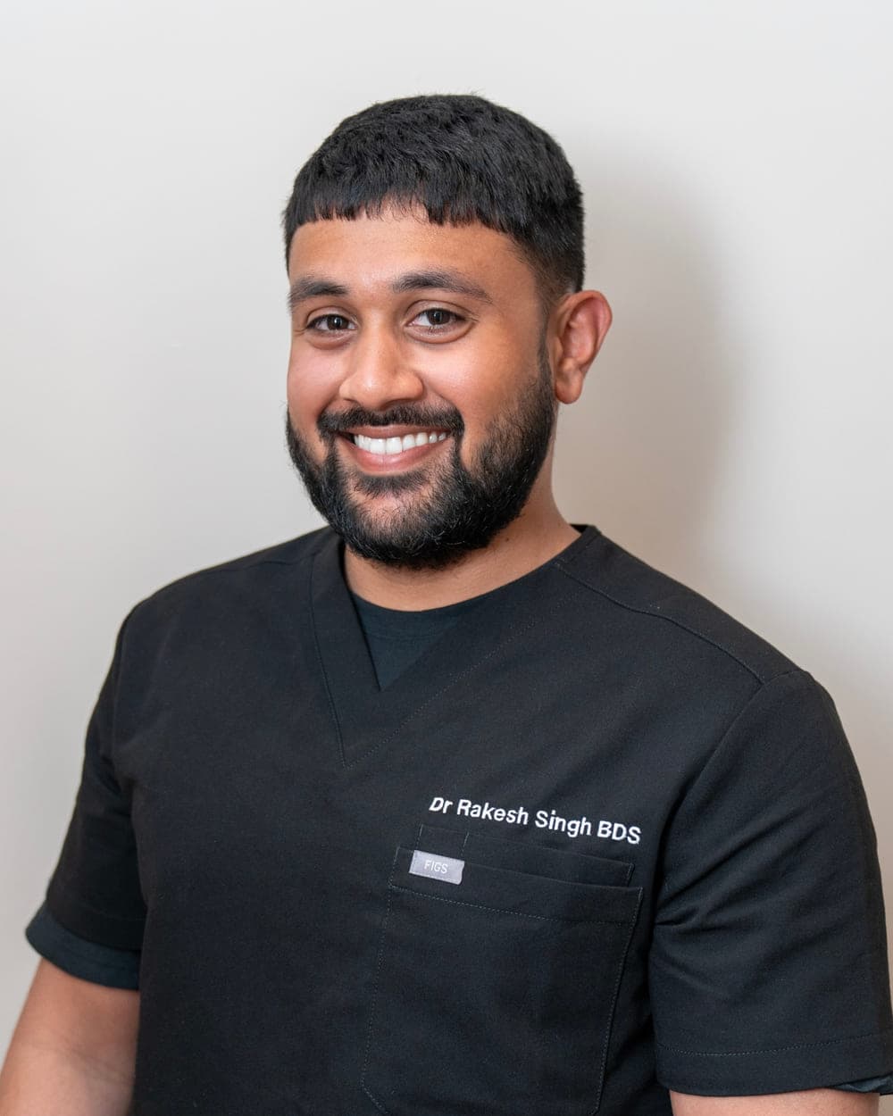 Dr Rakesh Singh, wearing dark clinical scrubs, photographed at the practice.